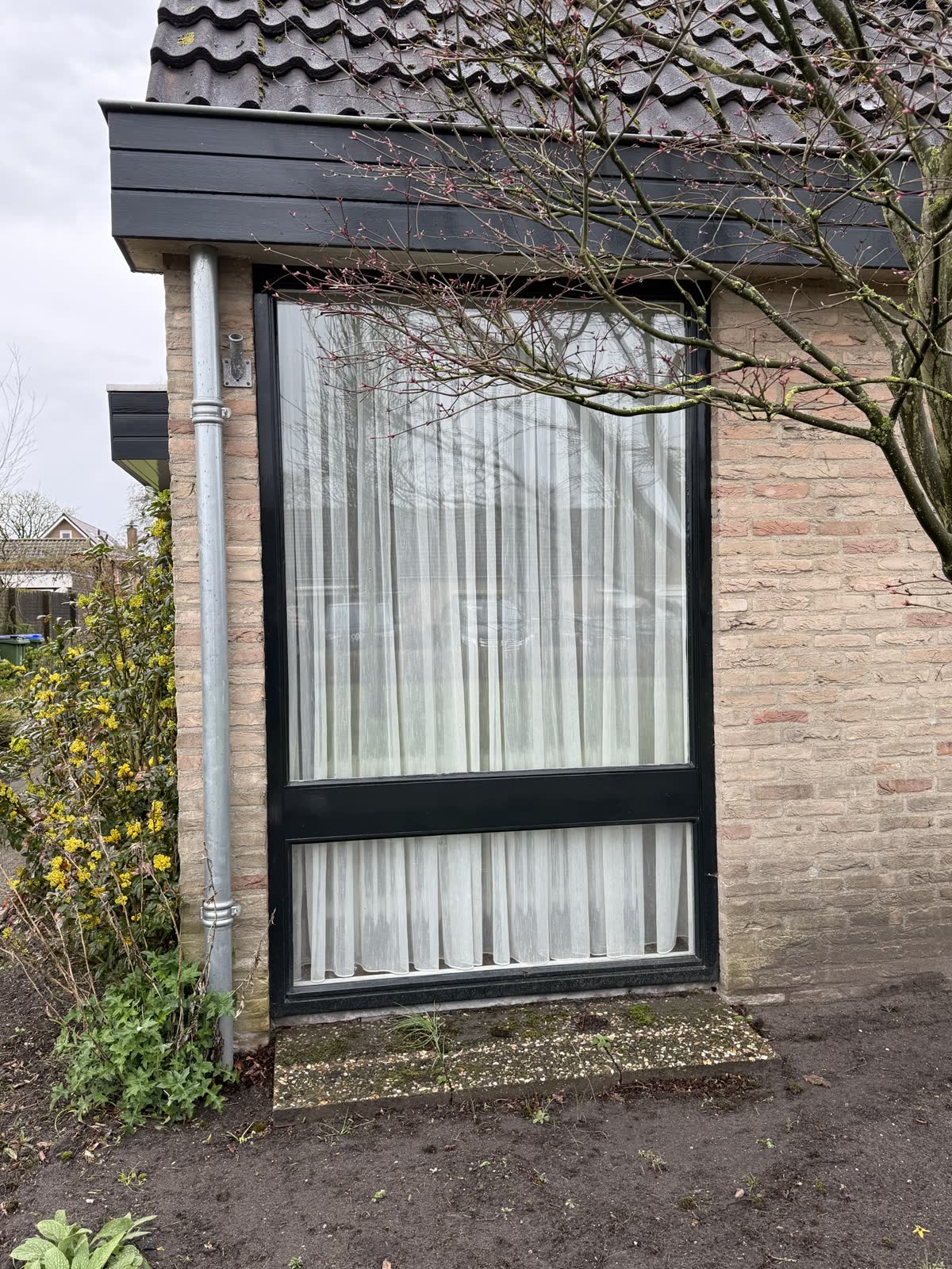 Hoog raam met donker kozijn
