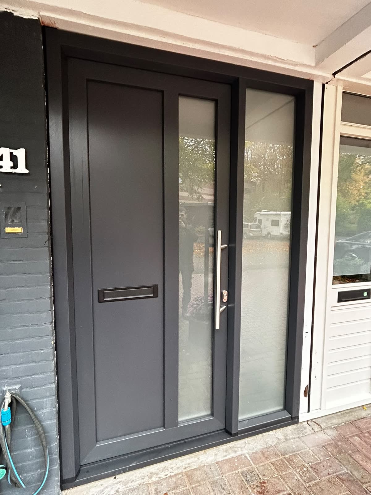 Nieuwe antraciet voordeur met glasstrook en glazen zijlicht