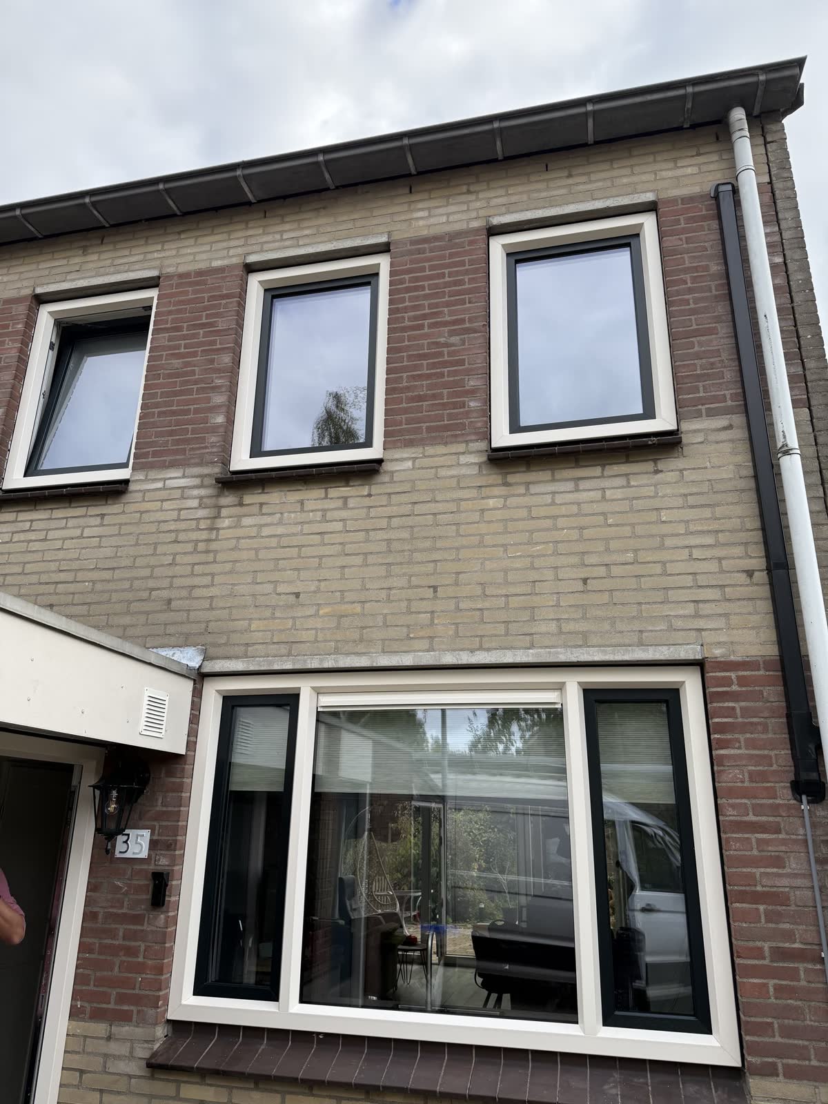 Voorgevel van een rijtjeshuis met witte kunststof ramen